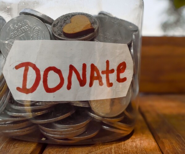 glass jar filled with coins and a piece of paper labeling it "donate"