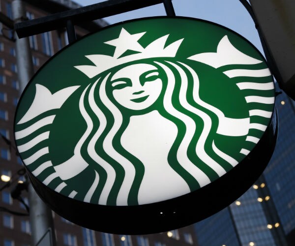 the starbucks logo is shown on the side in front of its building