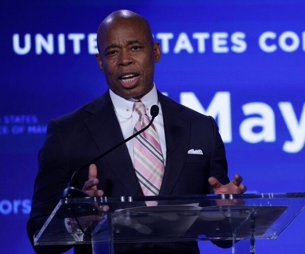 Eric Adams speaks into a microphone