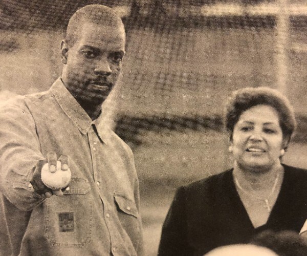 dwight good shows off a grip of his four-seam fastball as vera clemente looks on smiling