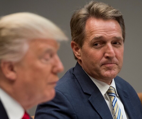 flake in a suit and striped tie looking over at trump 