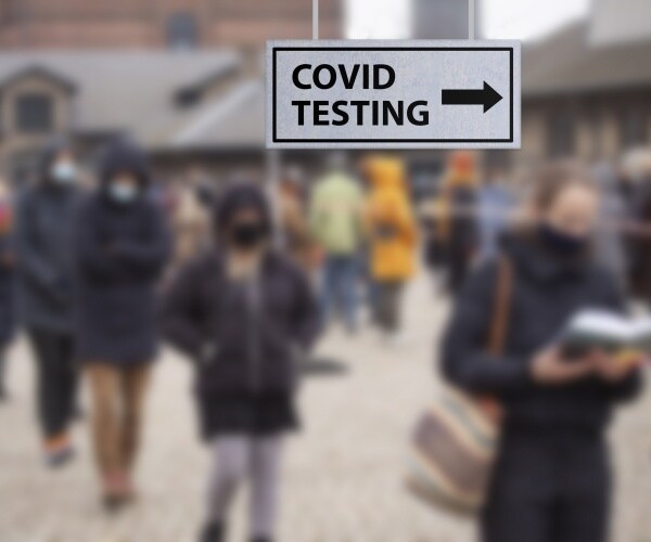 people waiting in long line outside in cold for COVID testing center
