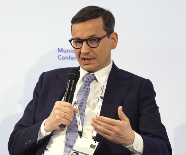 mateusz morawiecki speaks into a microphone
