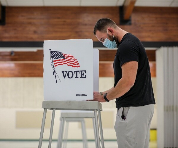 man votes in voting booth