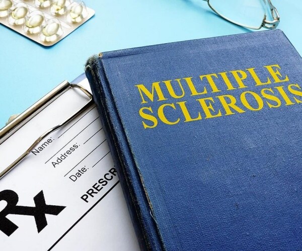 medical text on multiple sclerosis, pills, stethoscope