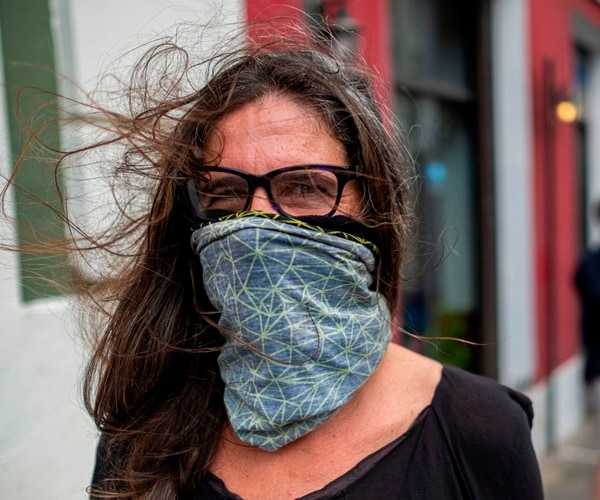 a woman wears a scarf to protect her face