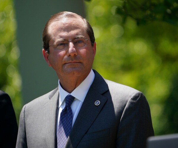 alex azar in a suit and navy blue tie standing outside