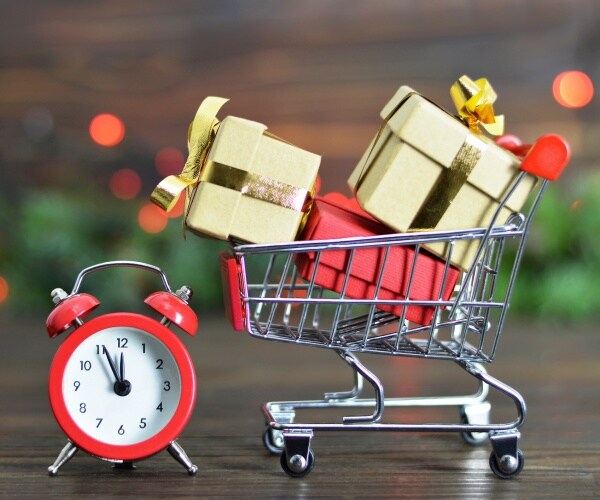gift boxes in a shopping cart with an alarm clock next to it