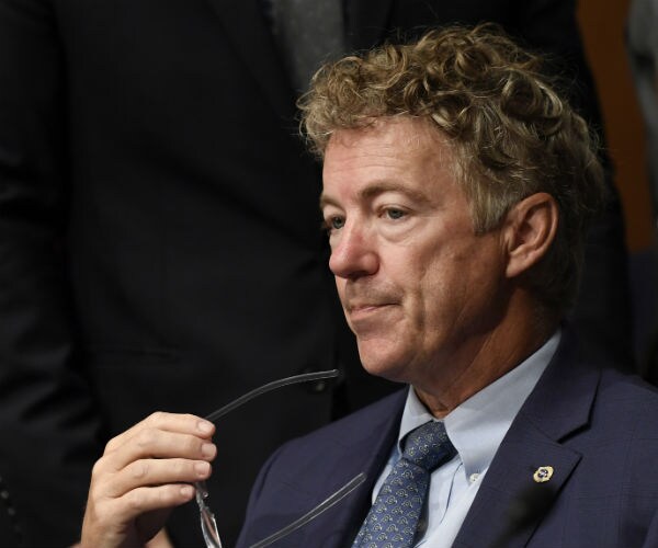 rand paul is shown holding his glasses