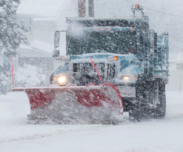 a snowplow drives through the snow