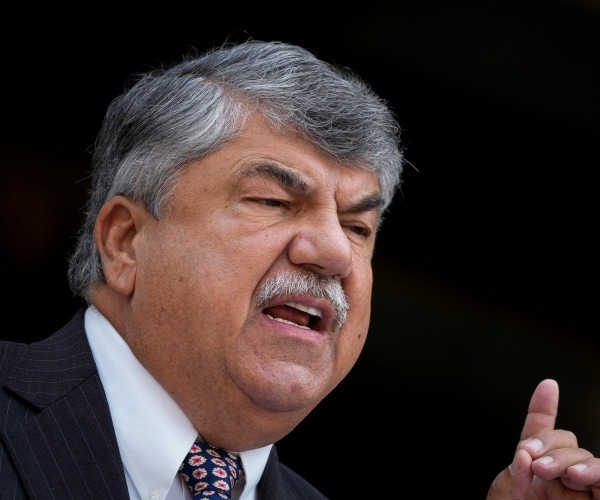 AFL-CIO President Richard Trumka speaking into a microphone at a news conference. 