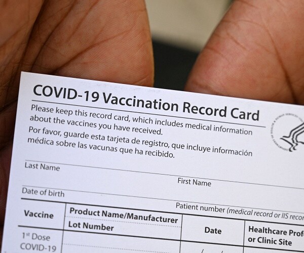 person holds vaccine card 
