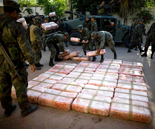 drugs seized from a mexican drug cartel is stacked by mexico military soldiers