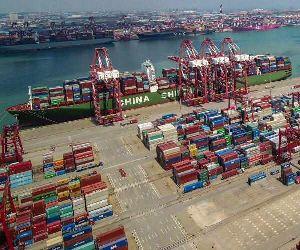a ship and shipping containers at a shipyard in china