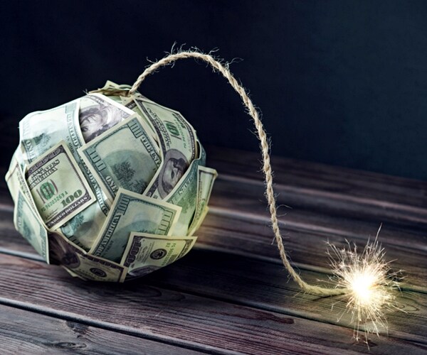 big bomb of money hundred dollar bills with a burning wick. little time before the explosion