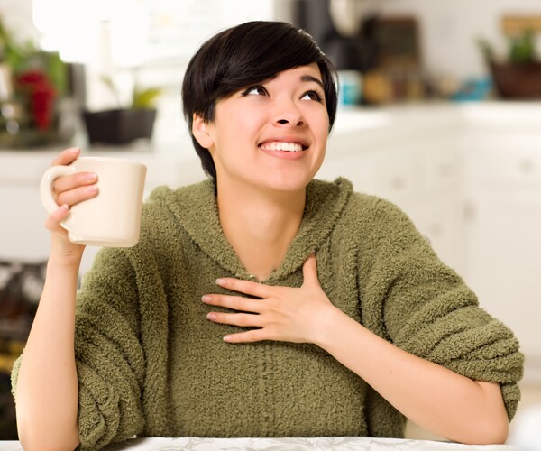a woman smiling and drinking coffee