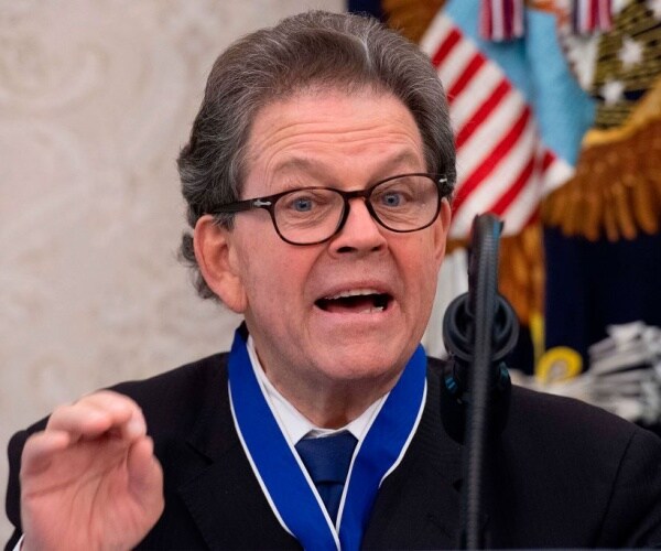 arthur laffer speaks with medal around neck and flag in background