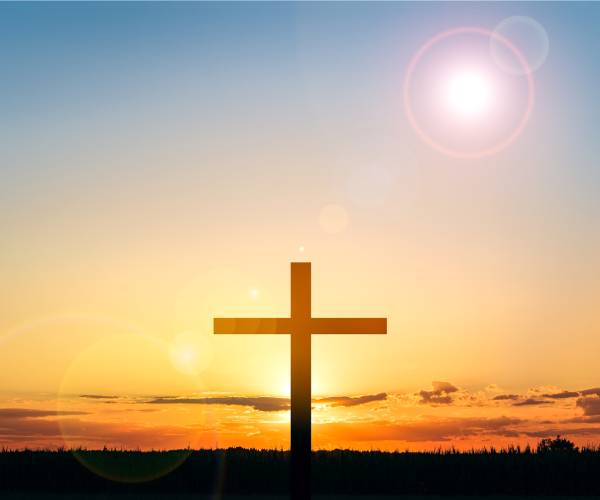 a cross seen with the sun behind it