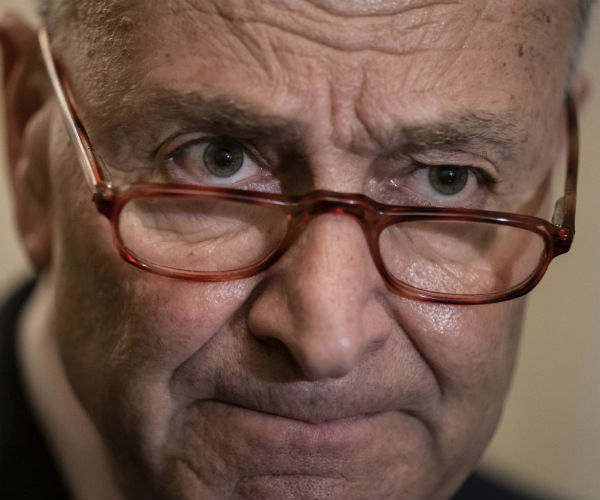 senate minority leader chuck schumer is shown with his glasses tipping off his nose