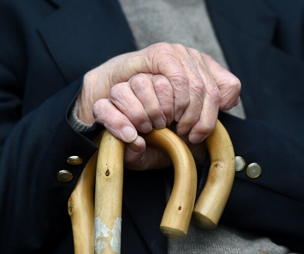 two people with canes, ones hand over the other's