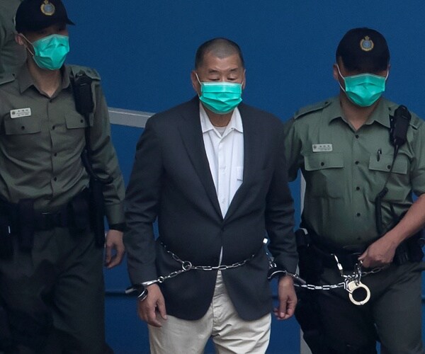 Jimmy Lai is escorted by Correctional Services officers to a prison van 