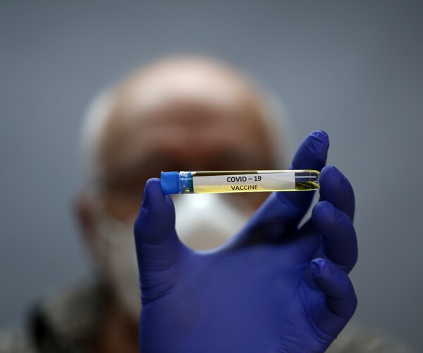 a man holding a covid-19 vaccine