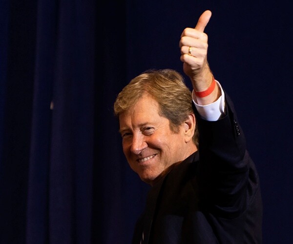 lewis in a suit giving a thumbs up and smiling