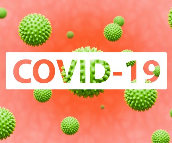 COVID-19 in block letters with coronavirus particles floating around it