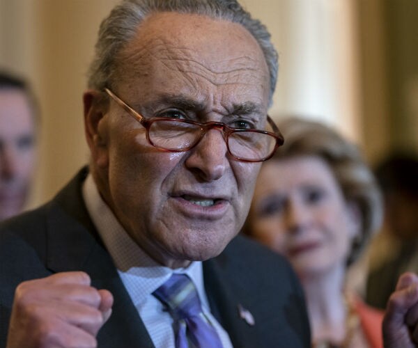 chuck schumer pumps his fist as he speaks with his red glasses tipping off his nose