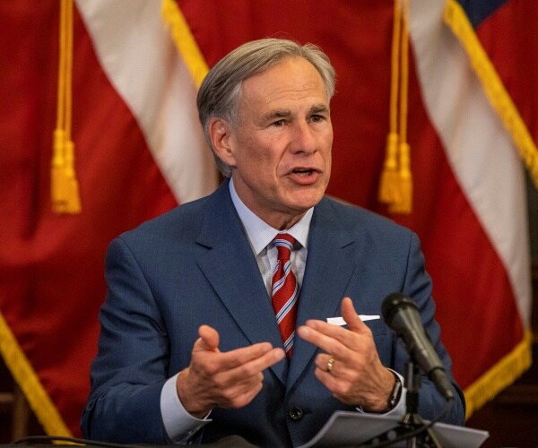 abbott in a navy blue suit and red striped tie