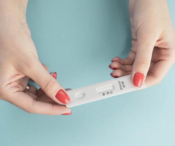 woman's hands holding a COVID test