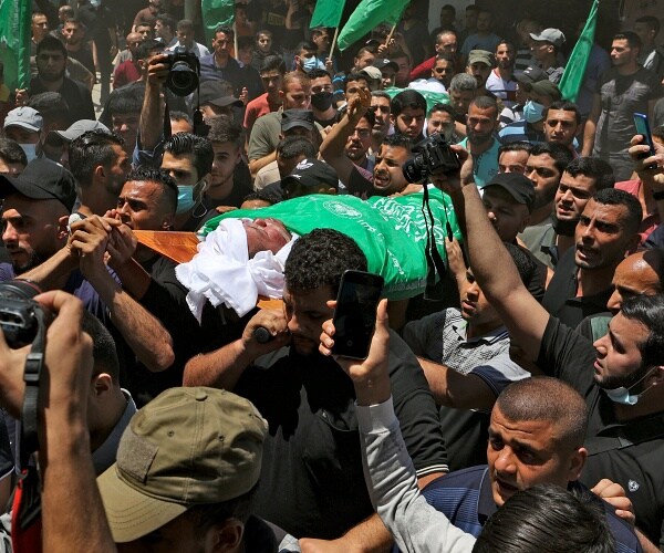 palestinian mourners hold up bod of leader