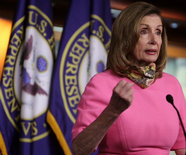 Speaker of the House Rep. Nancy Pelosi, in pink dress, participates in a news conference on capitol hill