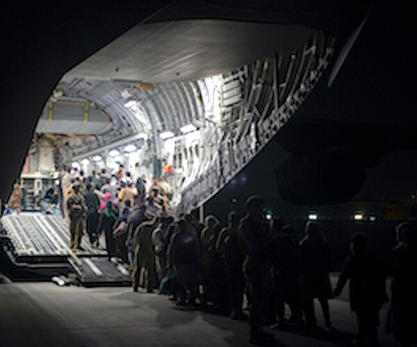 refugees entering a military transport vehicle