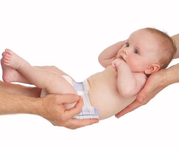 adult hands holding a baby like a swing