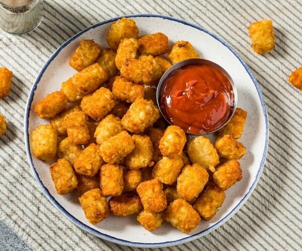 tater tots on a plate with ketchup