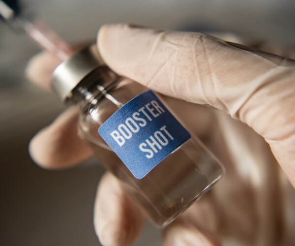 vial labeled 'booster shot' with syringe sticking out of it