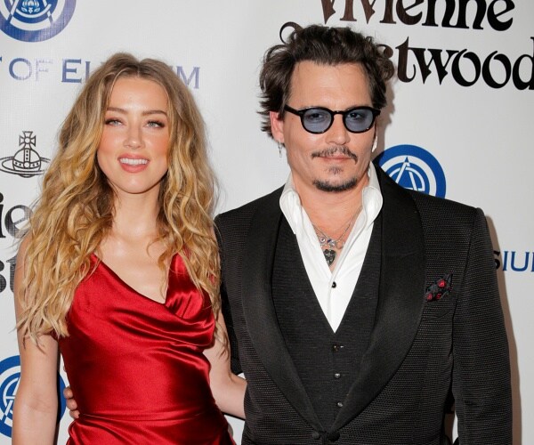 amber heard and johnny depp stand on red carpet