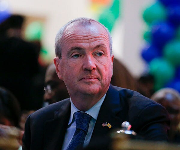 phil murphy sits at a celebration of his election