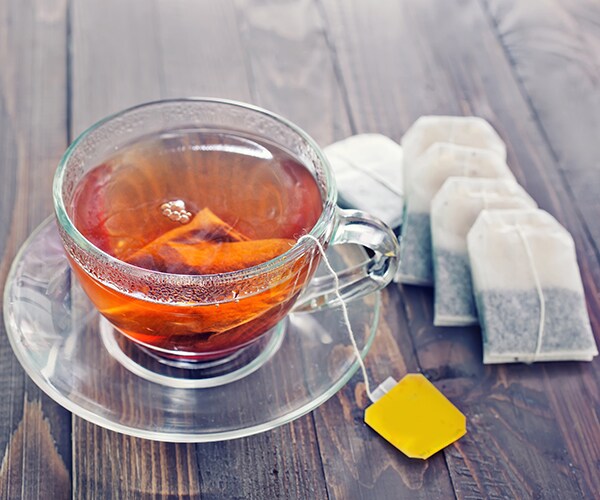 a cup of tea with a teabag in it and several teabags beside the cup