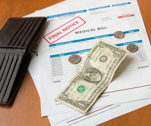 medical invoices marked 'final notice', empty wallet, dollar bill