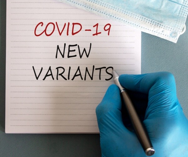 COVID-19 new variants on a writing pad and a pencil and mask