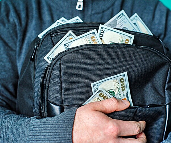 man holding a black briefcase with dollars. 

