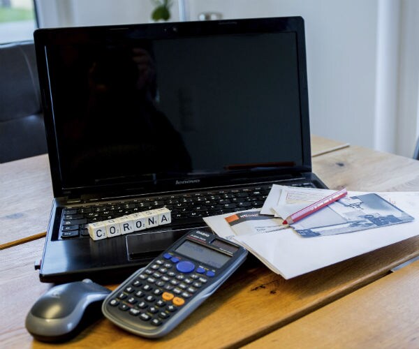 graphic shows a computer, calculator and bills sitting on top of a keyboard spelling out 'corona' 