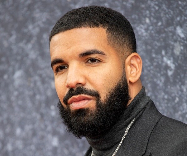 drake in a dark gray turtleneck and chain necklace