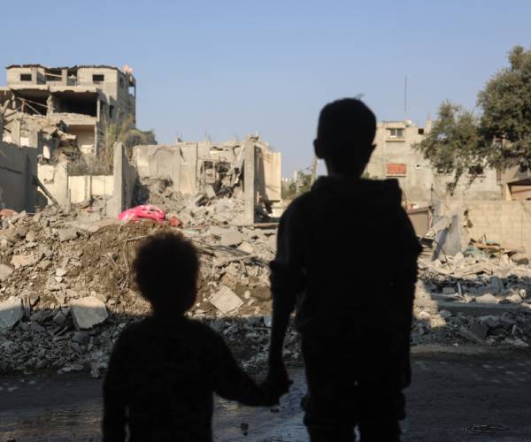 2 children look at rubble