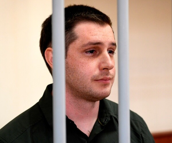 Trevor Reed stands inside a defendants' cage during.