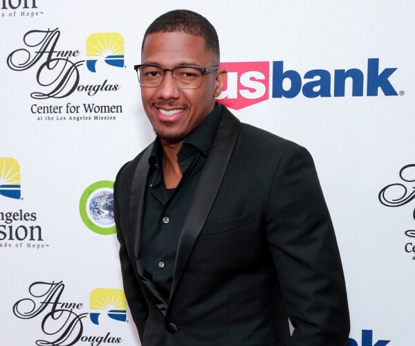nick cannon stands on red carpet