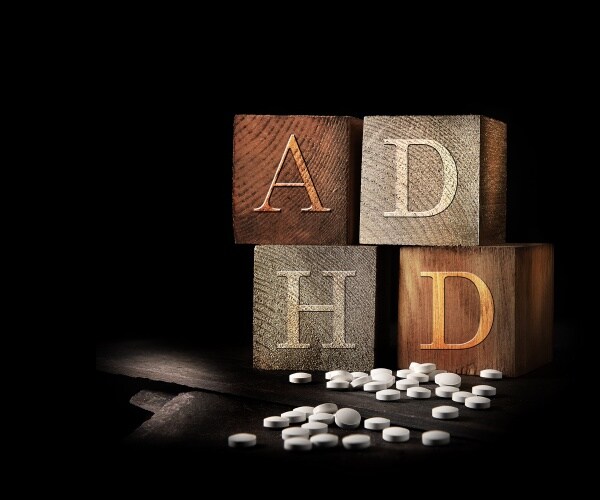set of blocks that spell out ADHD and some pills on table
