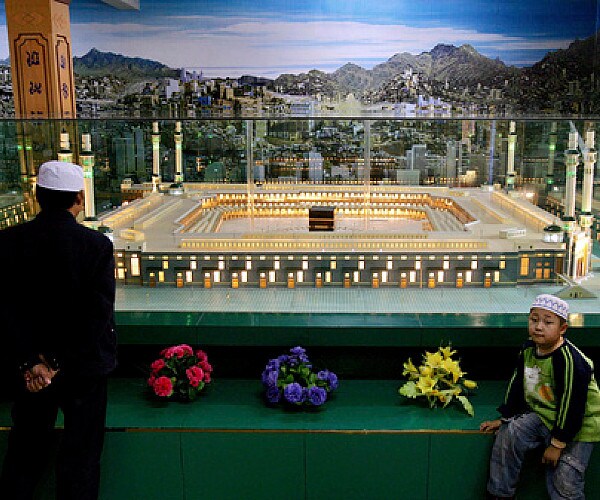 a man and a small boy in a chinese mosque